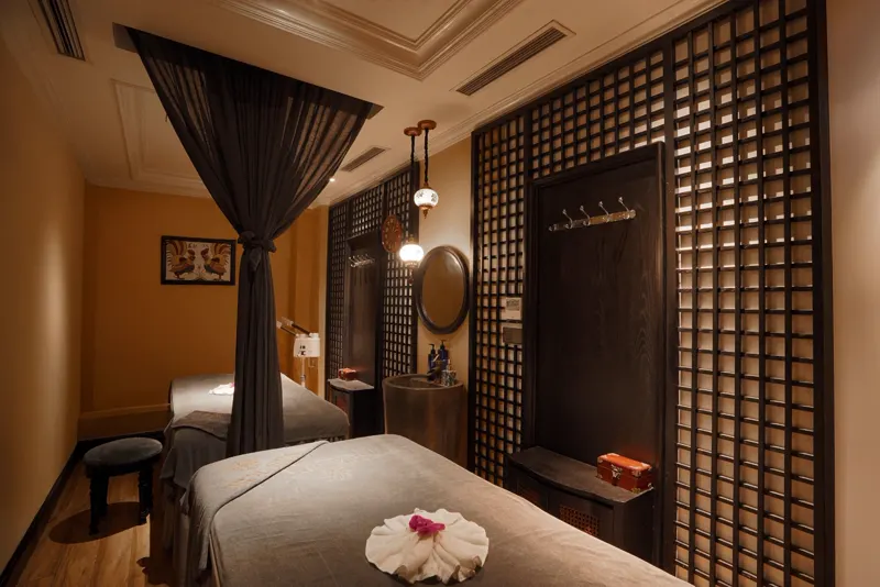 Treatment room with lantern light, a round mirror and a stone wash basin