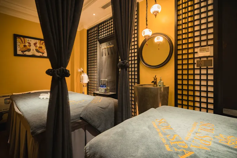 Twin treatment suite with Dong Ho folk paintings on ochre walls